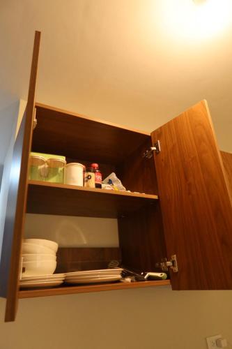 a cupboard with plates and dishes in it at Amori Spaces - MGD in Suba