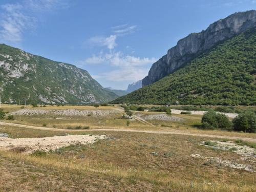 a road in a field with mountains in the background at Willage camp i auto camp KOMARNICA in Šavnik