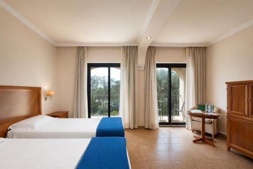 a hotel room with two beds and a balcony at Suites Del Borgo in Olbia