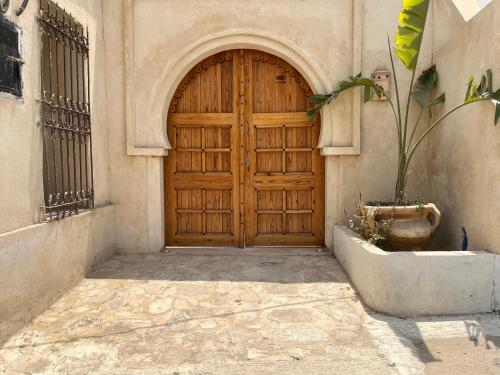a wooden door on the side of a building at Dar Younes in Houmt Souk