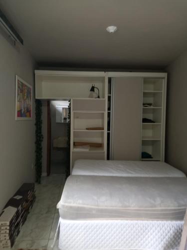 a bedroom with a white bed in a room at Conforto em Pomerode in Pomerode