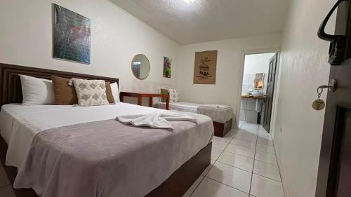 a hotel room with two beds and a bathroom at Basecamp Monteverde in Monteverde Costa Rica