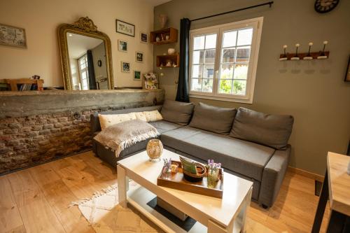 a living room with a couch and a table at gîte Cosy Green 2 in Chevincourt