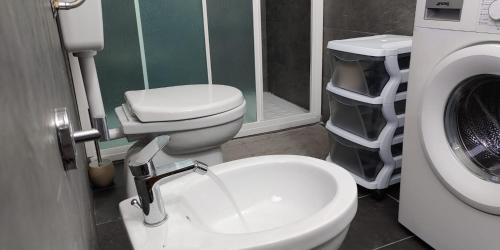 a bathroom with a toilet and a washing machine at Villa Costa Viola in San Roberto