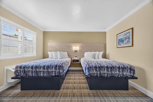 a hotel room with two beds and a window at Seaside Inn Monterey in Seaside
