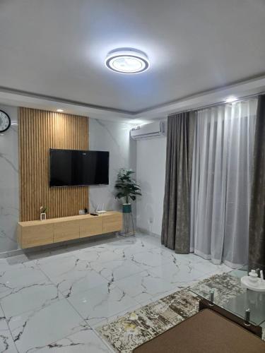 a living room with a flat screen tv on a wall at Résidences Laurence in Bingerville