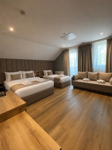 a hotel room with two beds and a couch at Maritime Łeba in Łeba