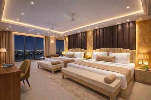 a hotel room with two beds and a couch at Hotel Luxury Inn Delhi Airport in New Delhi