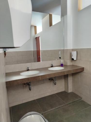 a public bathroom with two sinks and a toilet at Casa Reyna in Hacienda Cienguilla