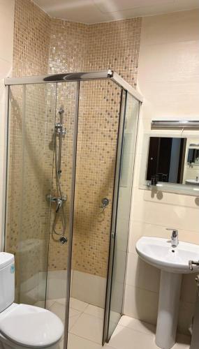 a bathroom with a shower and a toilet and a sink at Hôtel Telemly - Chaine El Djazair in Alger