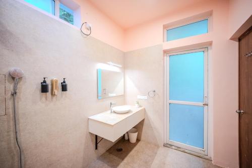 a white bathroom with a sink and a window at Aavaranaa Farmstay in Kanakapura