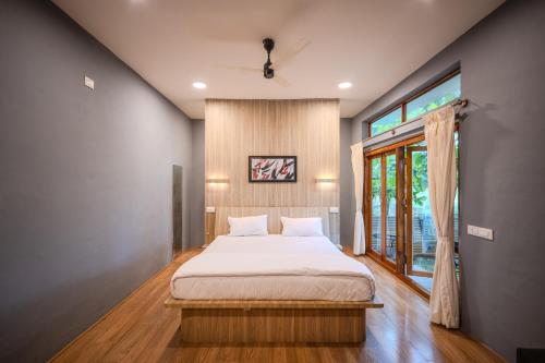 a bedroom with a large bed and a window at Aavaranaa Farmstay in Kanakapura