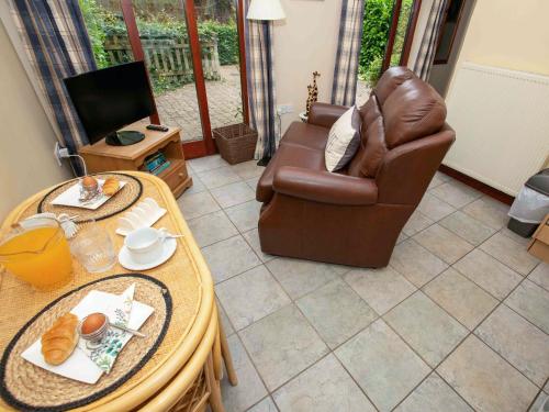 a living room with a leather chair and a table at Thyme - E4485 in Catfield