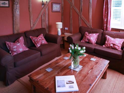 a living room with two couches and a coffee table at Bell Corner Cottage in Cratfield