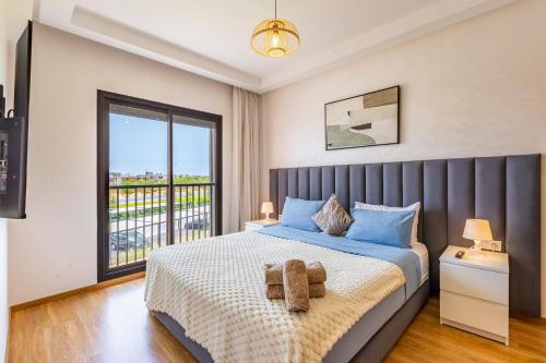 a bedroom with a bed with a large window at Appartement Noria Golf in El Makina