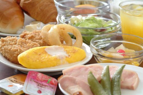 a plate of food with onion rings and vegetables on a table at Dormy Inn Kumamoto Natural Hot Spring in Kumamoto