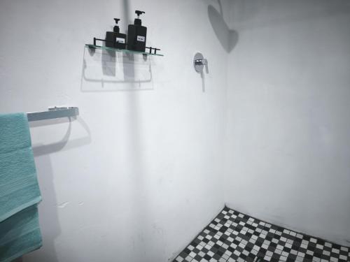 a white bathroom with a black and white checkered floor at Maphango Farms BnB in Alice