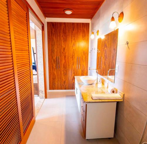 a bathroom with a sink and a counter with a mirror at Hotel Meaípe in Guarapari