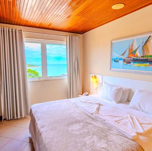 a bedroom with a large bed and a window at Hotel Meaípe in Guarapari