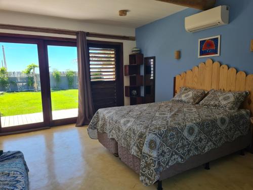a bedroom with a bed and a large window at Casa Bea in Fortim