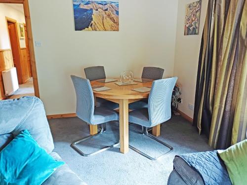 a dining room table with four chairs and a table at Park Lodge in Strachan