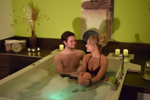 a man and a woman sitting in a bath tub at Kurhotel Bad Suderode in Bad Suderode