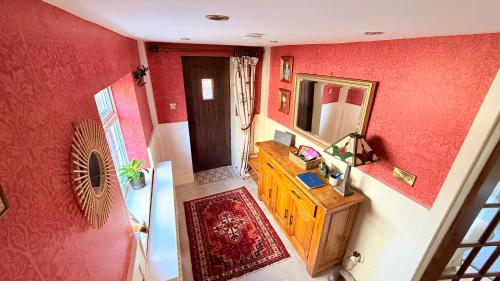 a bathroom with red walls and a sink and a mirror at River Views, Private Fishing & 9 min Train to York in Ulleskelf