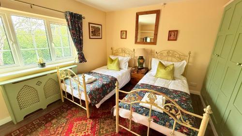 a bedroom with two beds and a window at River Views, Private Fishing & 9 min Train to York in Ulleskelf