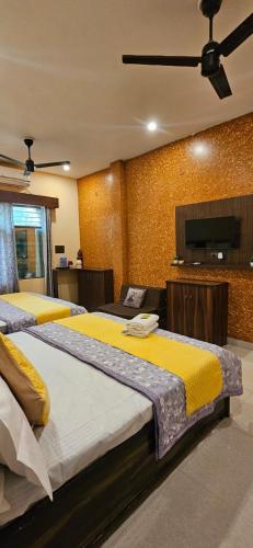 a bedroom with two beds and a flat screen tv at Krishna's land Homestay in Vrindāvan