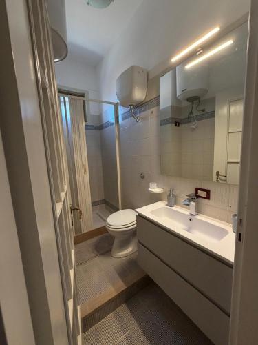 a bathroom with a white toilet and a sink at KolymBeddra in Agrigento