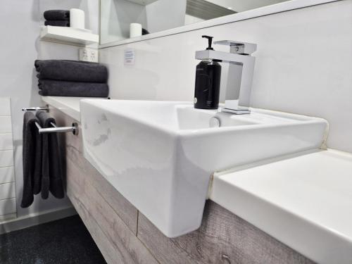 a white sink in a bathroom with towels at Apollo Bay Waterfront Motor Inn in Apollo Bay