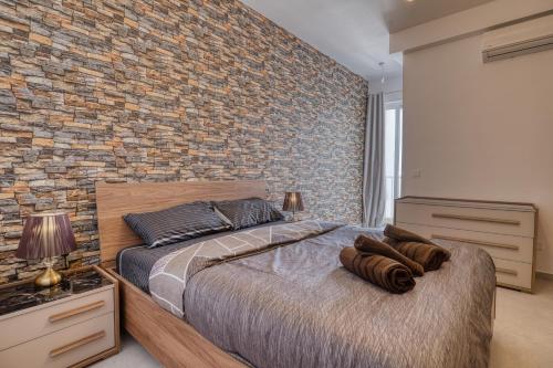 a bedroom with a brick wall and a bed at St Julian s Luxury Laura Apartments in Is-Swieqi