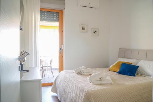 a white bedroom with a bed with two towels on it at Casa Eos in Bari