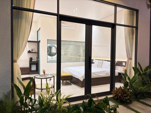 a bedroom with a bed and large windows at Samphia Homestay in Nguyệt Hòa