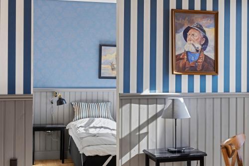 a bedroom with blue and white striped walls and a bed at Løkken Badehotel Apartments in Løkken