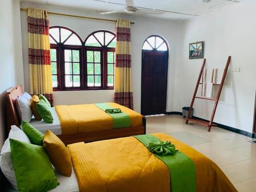 two beds in a room with yellow and green at Royal Mount Hotel in Pussellawa