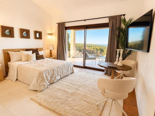 a bedroom with a bed and a window with a view at Villa Ottavio Costa Smeralda View 360 in San Pantaleo