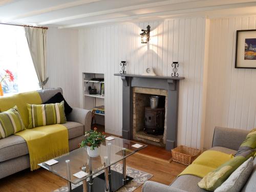a living room with two couches and a fireplace at Wee Dug Hoose in Glenluce