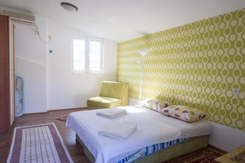 a small bedroom with a bed and a chair at Apartments Old Town in Budva