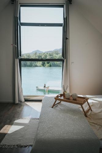 a living room with a large window and a coffee table at Vikendica Family in Gojsalica
