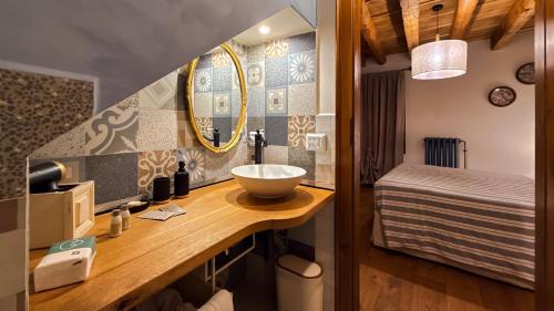 a bathroom with a sink and a mirror and a bed at B&b ANTICO MAGLIO in Asolo