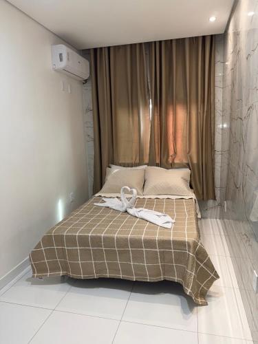 a bedroom with a bed with a towel on it at Pacheco Pousada in Sabará