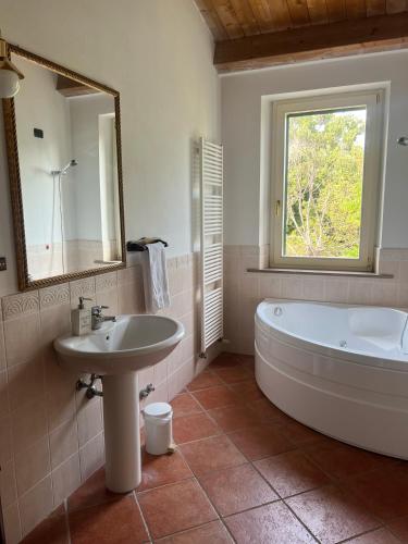 a bathroom with a tub and a sink and a mirror at A casa di Leyla in Monteluro
