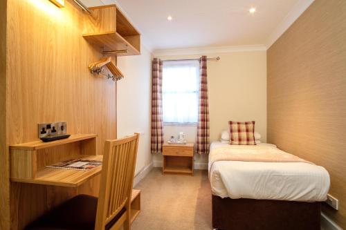 a small room with a bed and a desk and a bedroom at Adamson Hotel in Dunfermline