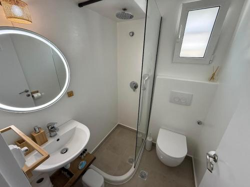 a white bathroom with a sink and a mirror at Nion Stays in Katapola