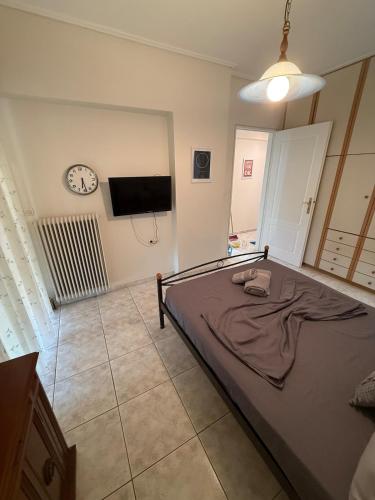 a bedroom with a bed and a clock on the wall at Velinora House in Rafina