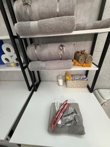 a shelf with folded towels and a basket of utensils at Velinora House in Rafina