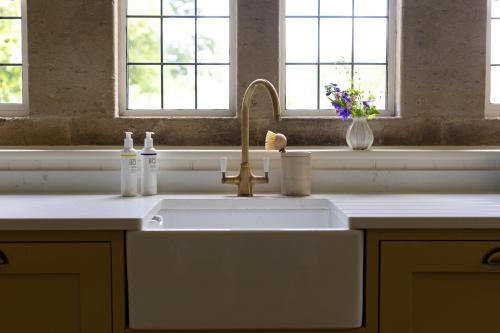 a kitchen sink with two bottles on it at Costers Lodge in Midhurst