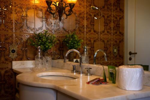 a kitchen counter with a sink and two faucets at Dom Ravello in Telêmaco Borba