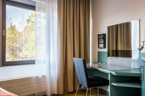 a desk with a chair next to a window at Scandic Rosendahl in Tampere